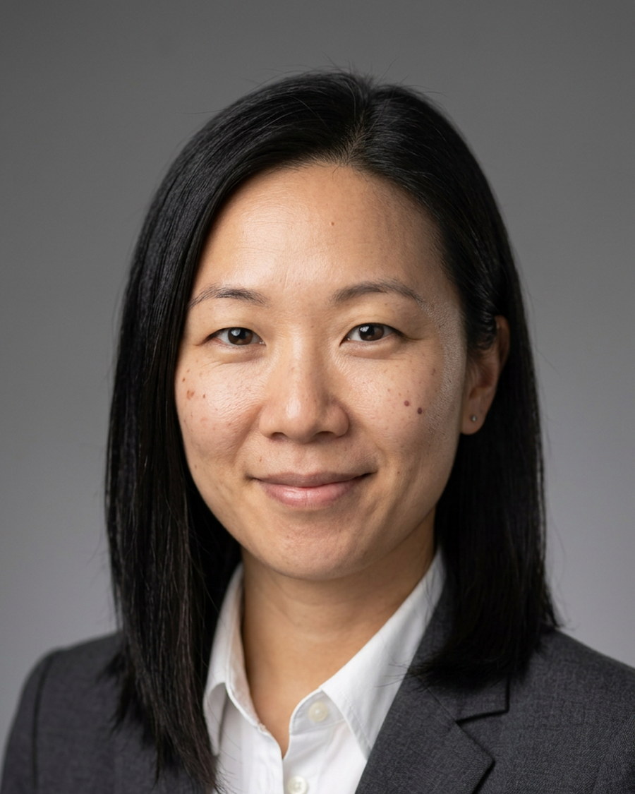 Corporate headshot of a woman against a grey studio background